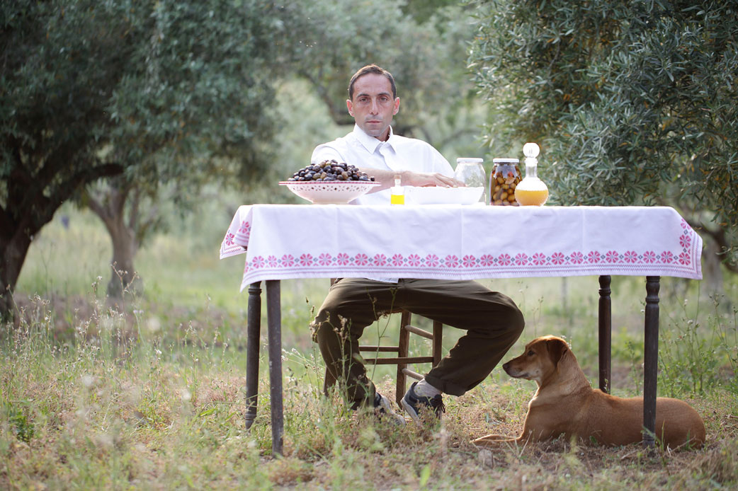 Gründer Antonino Cutrona der Olivenölmanufaktur OlivenOnkel sitzt am Tisch auf dem seine Produkte stehen